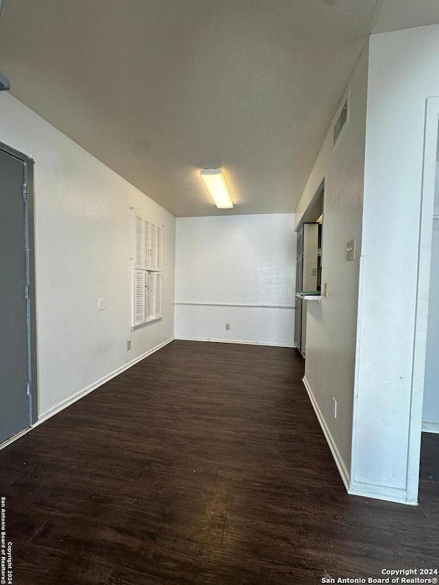 unfurnished room with dark hardwood / wood-style flooring