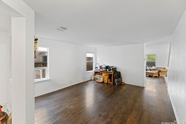 interior space with a textured ceiling, dark hardwood / wood-style flooring, and plenty of natural light