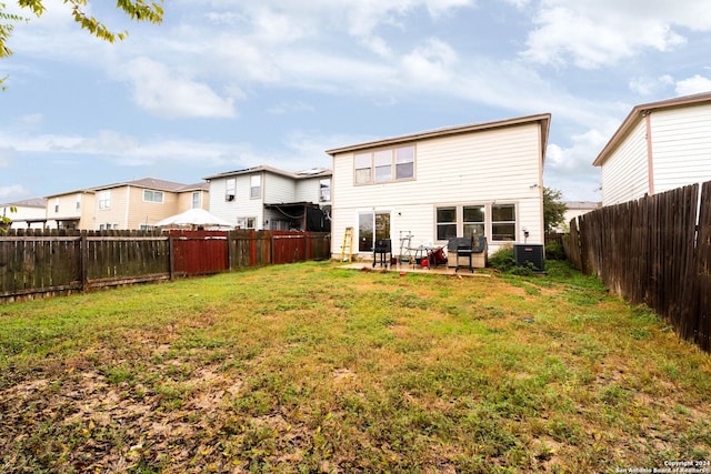 back of property featuring a lawn, cooling unit, and a patio