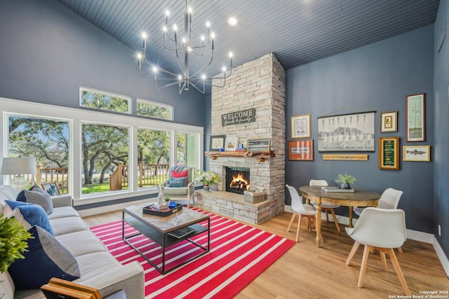 living room featuring high vaulted ceiling, light wood-type flooring, a fireplace, wood ceiling, and a chandelier