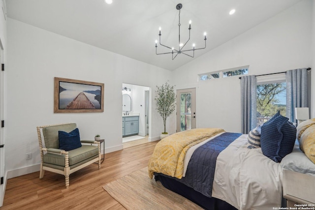 bedroom featuring a chandelier, high vaulted ceiling, light hardwood / wood-style flooring, and ensuite bath