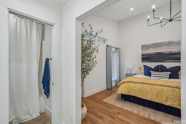 bedroom featuring an inviting chandelier and hardwood / wood-style flooring