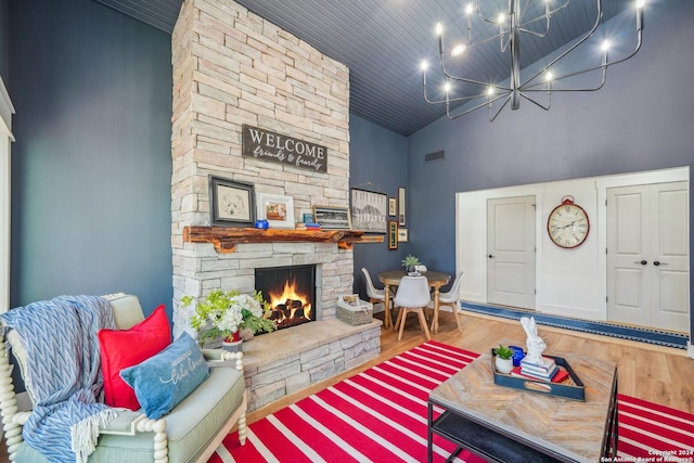 living room featuring hardwood / wood-style flooring, high vaulted ceiling, wooden ceiling, a notable chandelier, and a fireplace