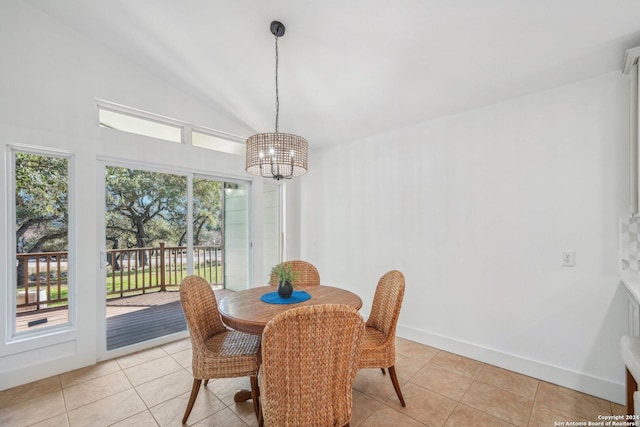 dining space with light tile patterned floors, lofted ceiling, and a notable chandelier