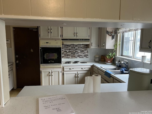 kitchen featuring wall oven, decorative backsplash, white gas stovetop, and sink