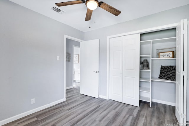 unfurnished bedroom with hardwood / wood-style floors, a closet, and ceiling fan