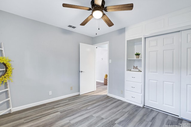 unfurnished bedroom with light wood-type flooring, a closet, and ceiling fan