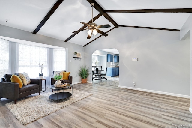 living room featuring beamed ceiling, ceiling fan, light wood-type flooring, and high vaulted ceiling