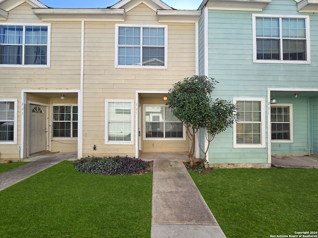 townhome / multi-family property featuring a front lawn