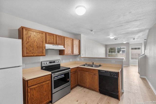 kitchen featuring stainless steel range with electric stovetop, white refrigerator, sink, black dishwasher, and light hardwood / wood-style floors