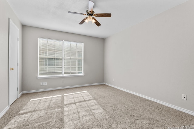 empty room featuring ceiling fan and light colored carpet