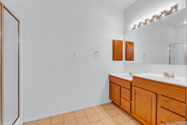 bathroom featuring a shower with door and vanity