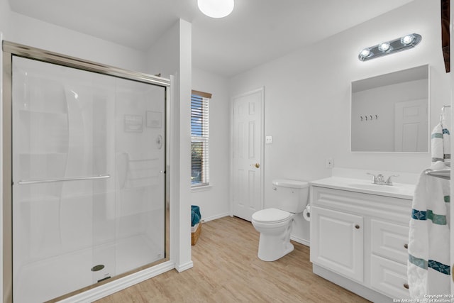 bathroom featuring vanity, hardwood / wood-style flooring, toilet, and a shower with shower door