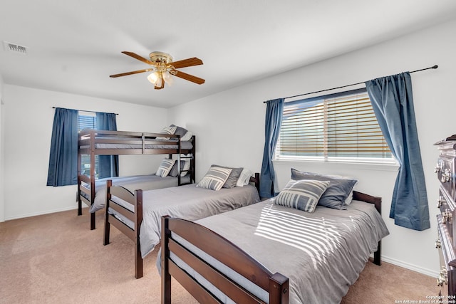 carpeted bedroom with multiple windows and ceiling fan