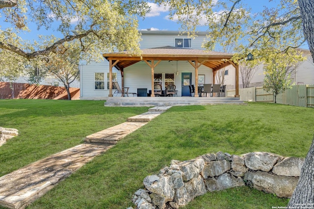 rear view of house with a lawn and a patio