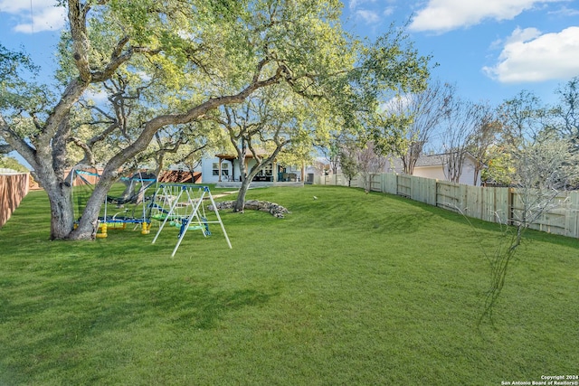 view of yard with a playground and a trampoline