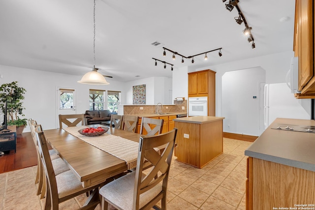 dining space featuring sink, light tile patterned floors, and track lighting