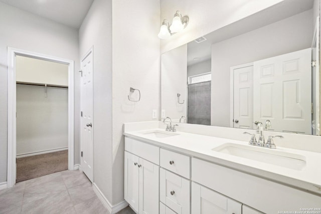 bathroom with tile patterned floors, vanity, and walk in shower