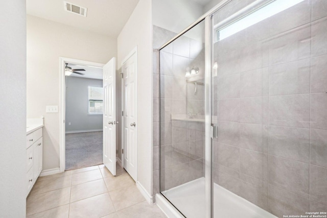 bathroom featuring tile patterned flooring, vanity, an enclosed shower, and a wealth of natural light