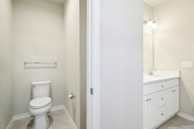 bathroom featuring tile patterned flooring, vanity, and toilet