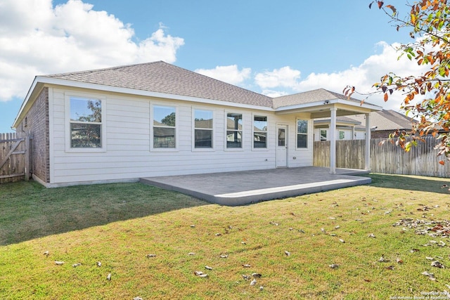 rear view of property with a yard and a patio