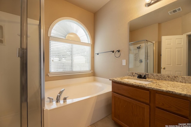 bathroom featuring shower with separate bathtub, vanity, and tile patterned floors