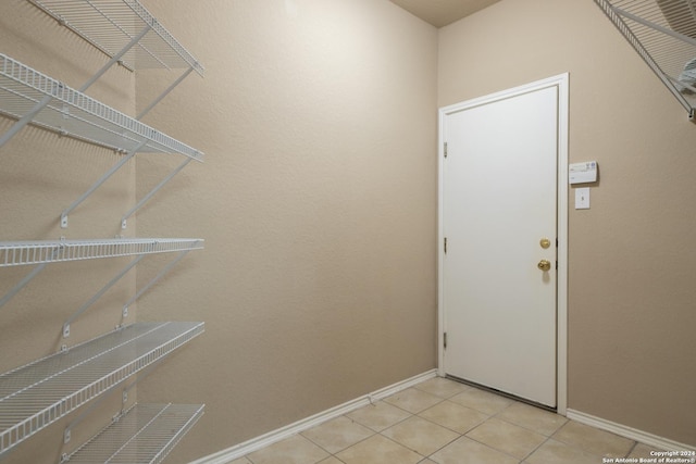 clothes washing area featuring light tile patterned floors