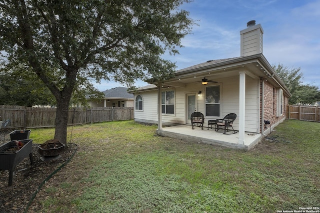 back of house featuring ceiling fan, a yard, and a patio