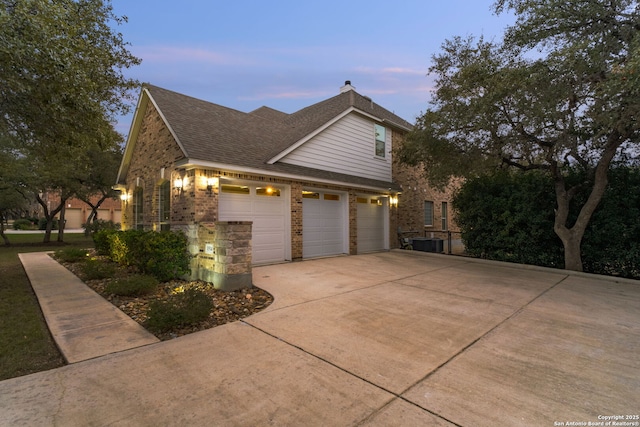 property exterior at dusk featuring a garage and cooling unit