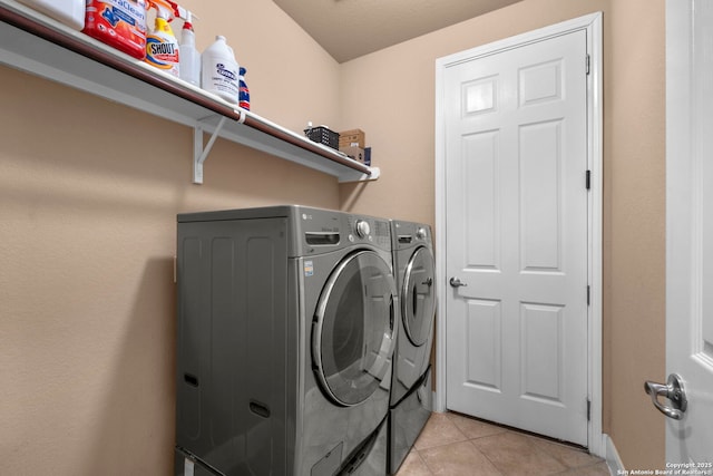 laundry room with washer and clothes dryer and light tile patterned floors