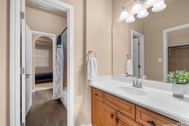 bathroom featuring vanity, shower / bath combination with curtain, and an inviting chandelier