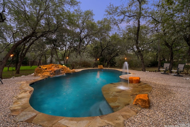 pool at dusk with pool water feature