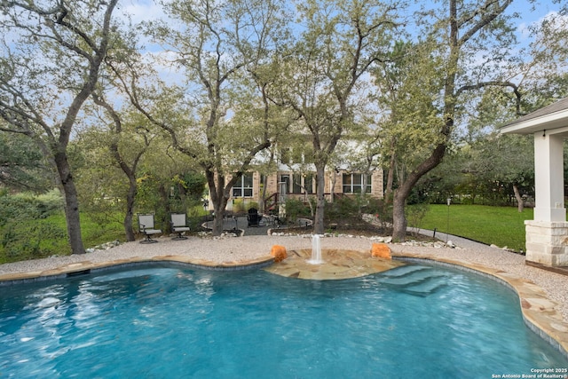 view of swimming pool with a yard