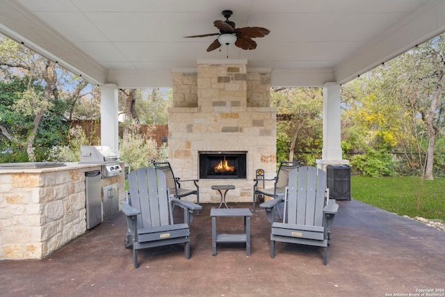 view of patio / terrace featuring area for grilling and an outdoor stone fireplace