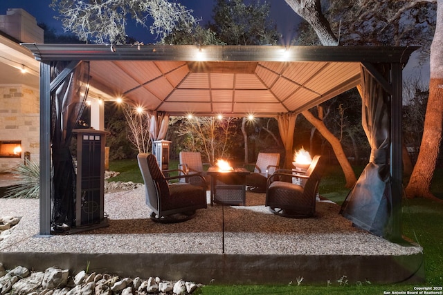 patio at twilight with a gazebo and an outdoor living space