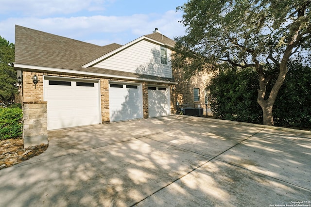 view of home's exterior with a garage and central air condition unit