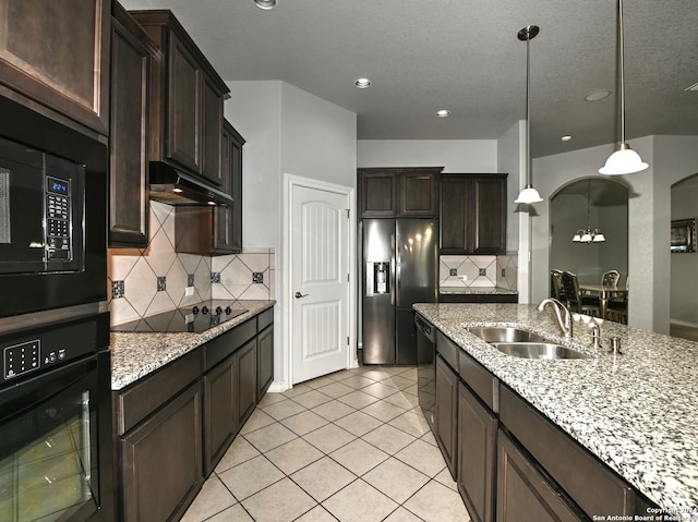 kitchen featuring black appliances, sink, hanging light fixtures, tasteful backsplash, and light tile patterned flooring