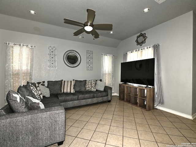 living room with tile patterned floors, ceiling fan, a textured ceiling, and lofted ceiling