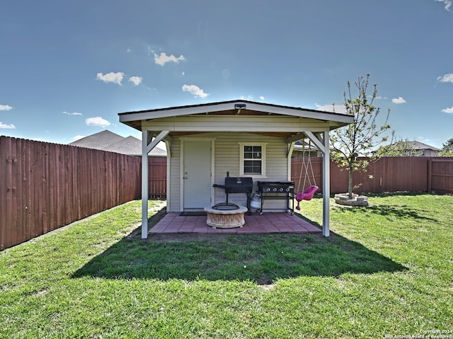 rear view of house with a fire pit, a patio area, and a lawn