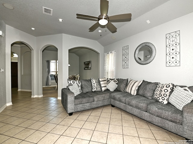 tiled living room featuring a textured ceiling, ceiling fan, and lofted ceiling