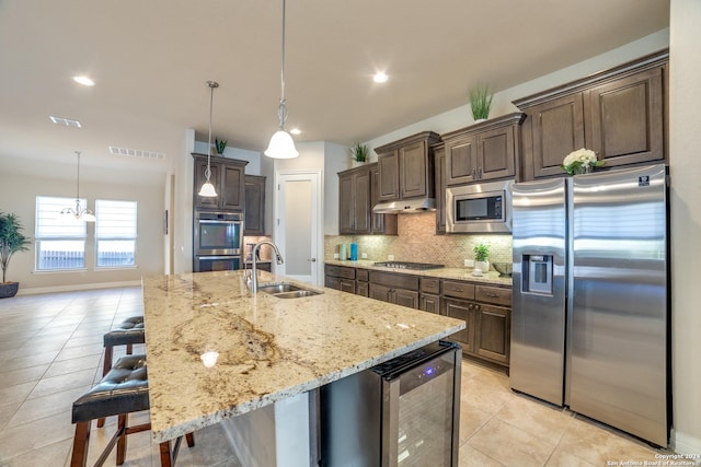 kitchen featuring wine cooler, sink, hanging light fixtures, and appliances with stainless steel finishes