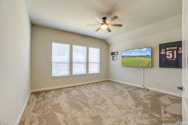 carpeted spare room with ceiling fan and vaulted ceiling