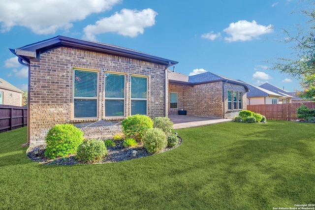 rear view of property with a patio area and a yard