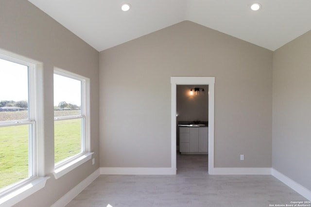 unfurnished room featuring lofted ceiling