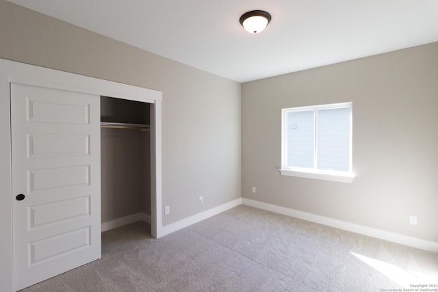 unfurnished bedroom featuring a closet and light colored carpet