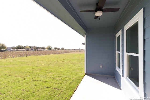 view of yard with a rural view and ceiling fan