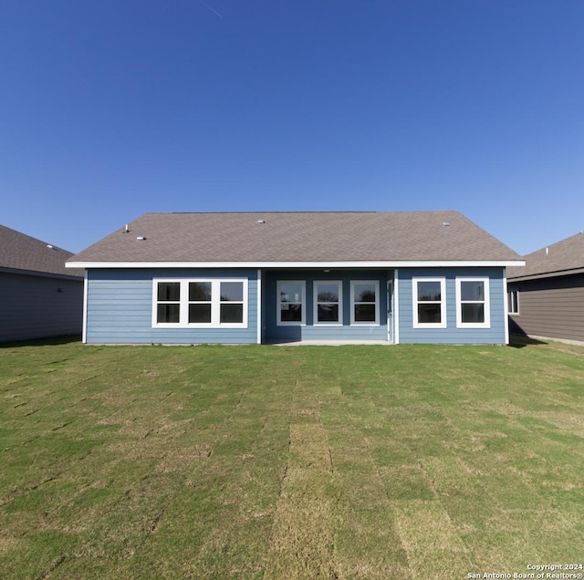 rear view of property with a yard