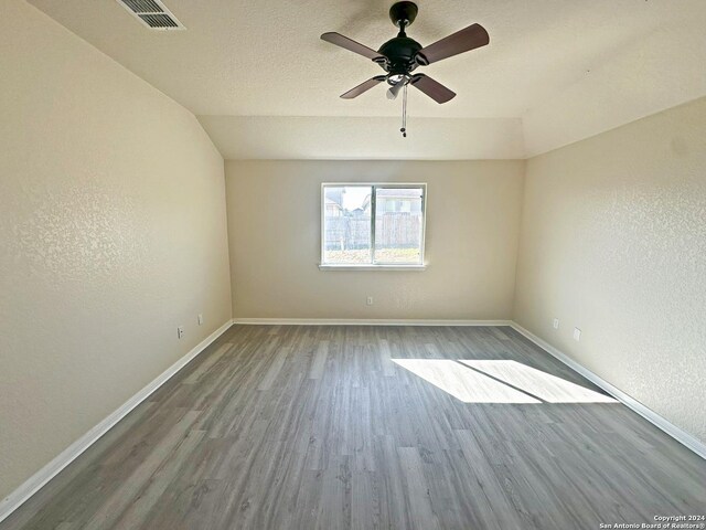 spare room featuring ceiling fan, wood-type flooring, and lofted ceiling