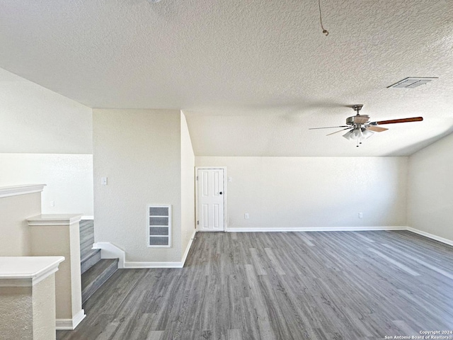 bonus room featuring vaulted ceiling, ceiling fan, a textured ceiling, and hardwood / wood-style flooring