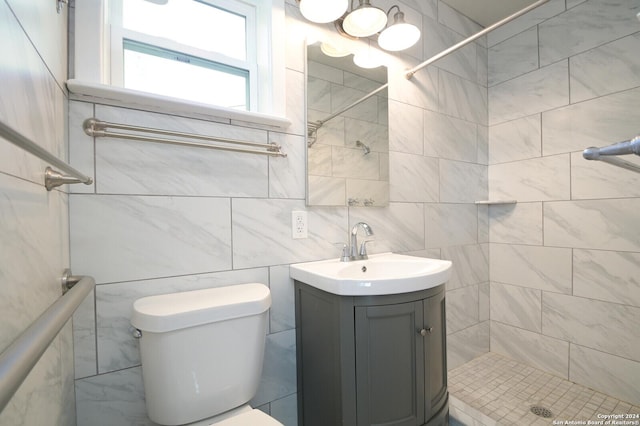 bathroom with vanity, tile walls, and toilet